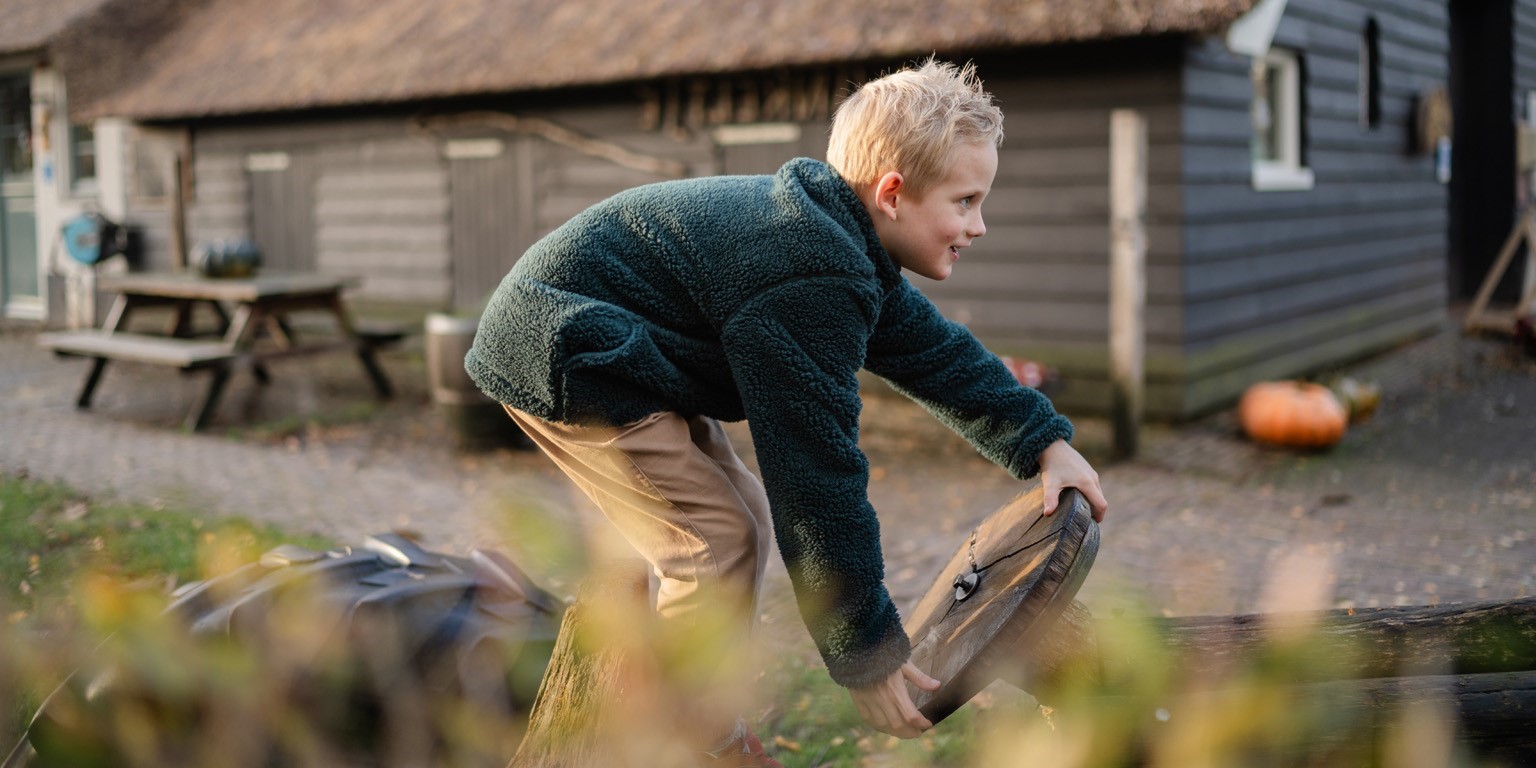 Jongen staat op houten auto