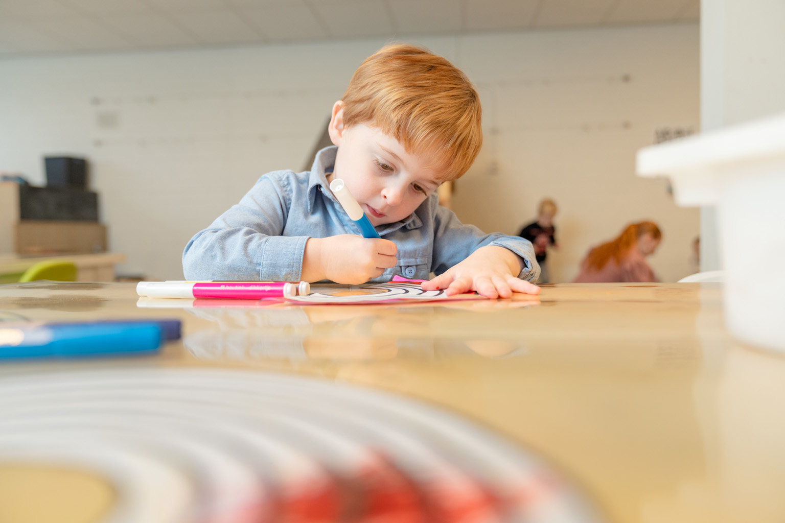 Jongen is bezig met het inkleuren van zijn tekening
