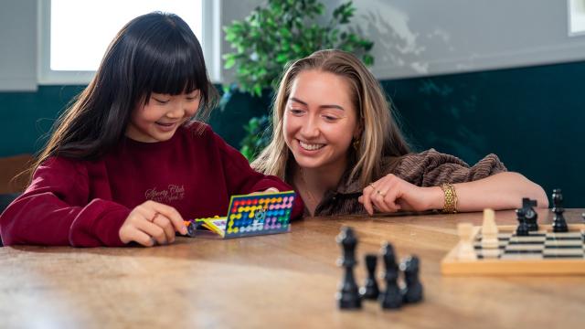 Pedagogisch professional met kind aan tafel