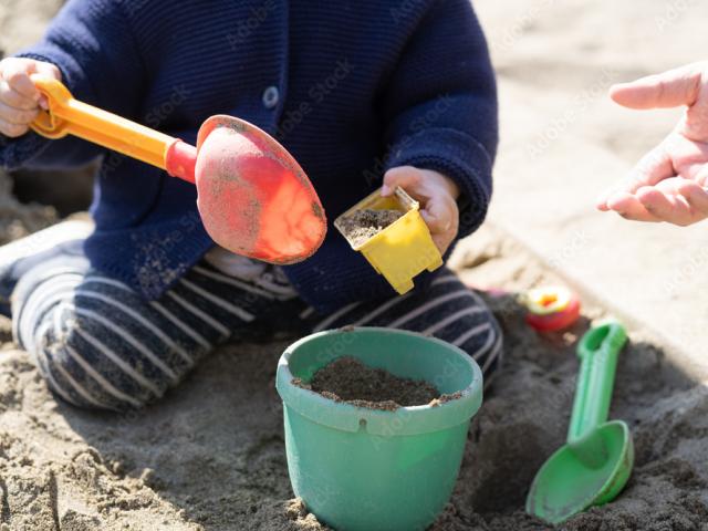 kind speelt met emmer en schep in de zandbak bij bijdehandjes kinderopvang