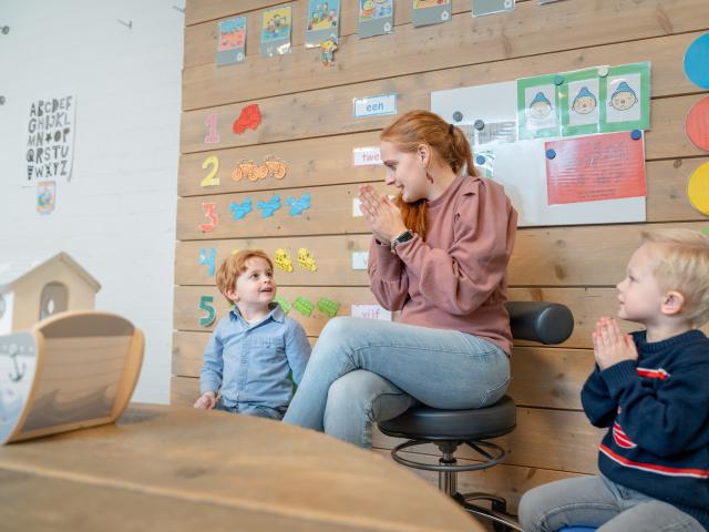 pedagogisch medewerker zit in kring met kinderen