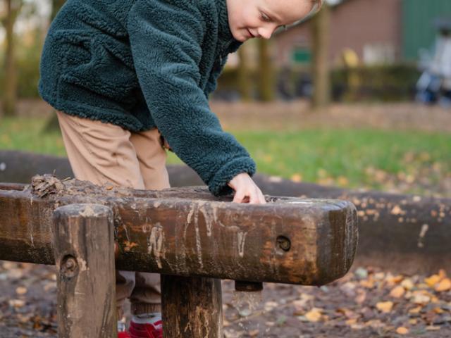 Jongen speelt in modder