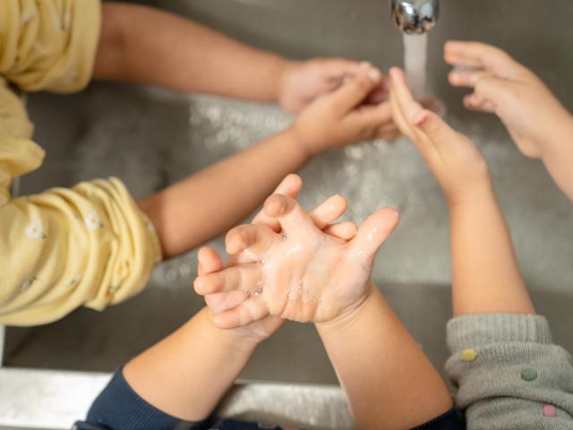 Kinderen wassen hun handen onder de kraan