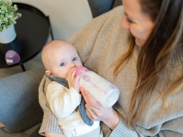 Baby krijgt de fles van een pedagogisch professional