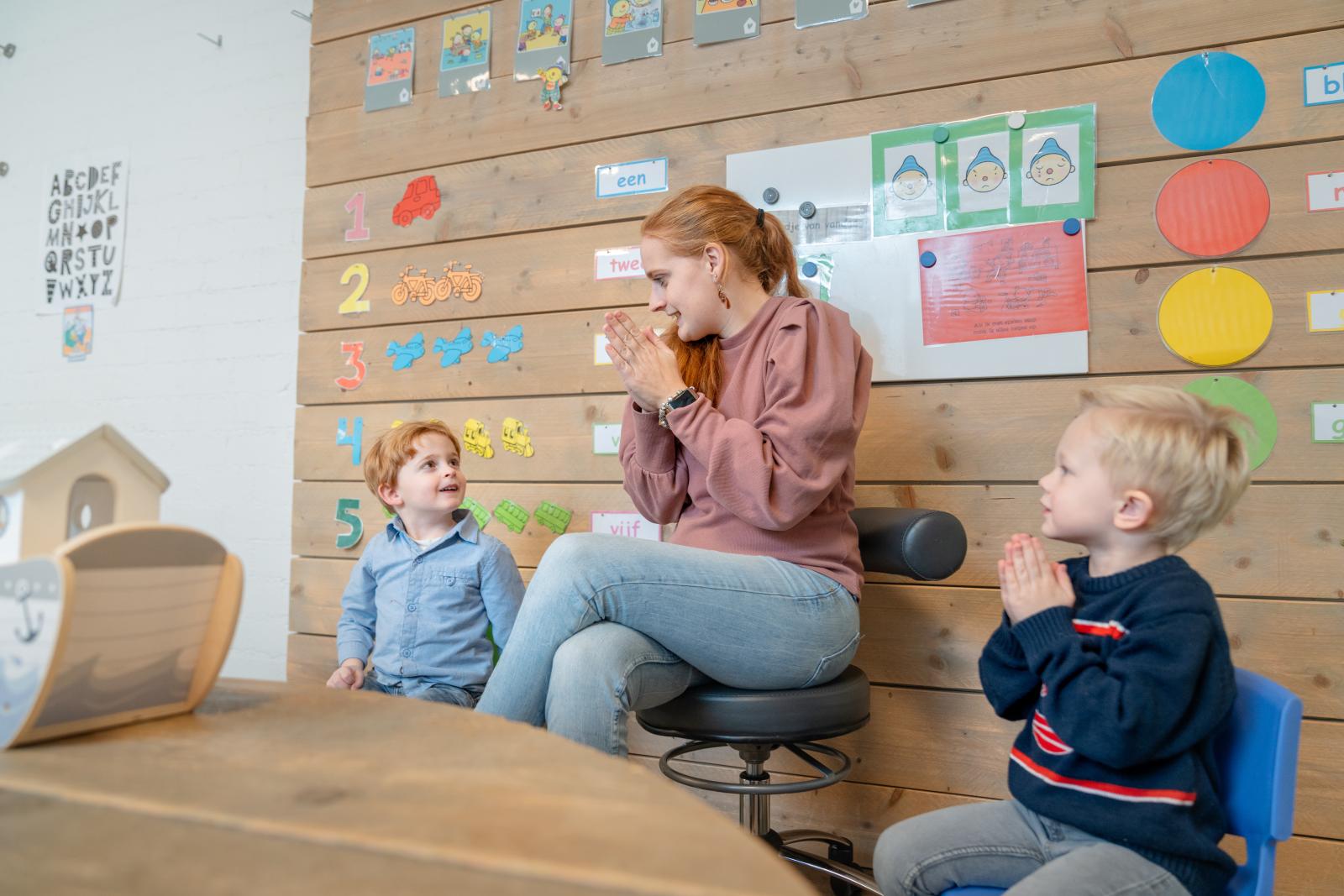 pedagogisch medewerker zit in kring met kinderen