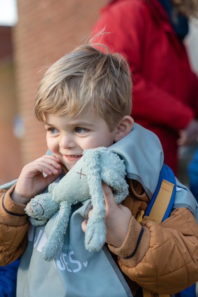 Kind lacht met knuffeltje in de hand