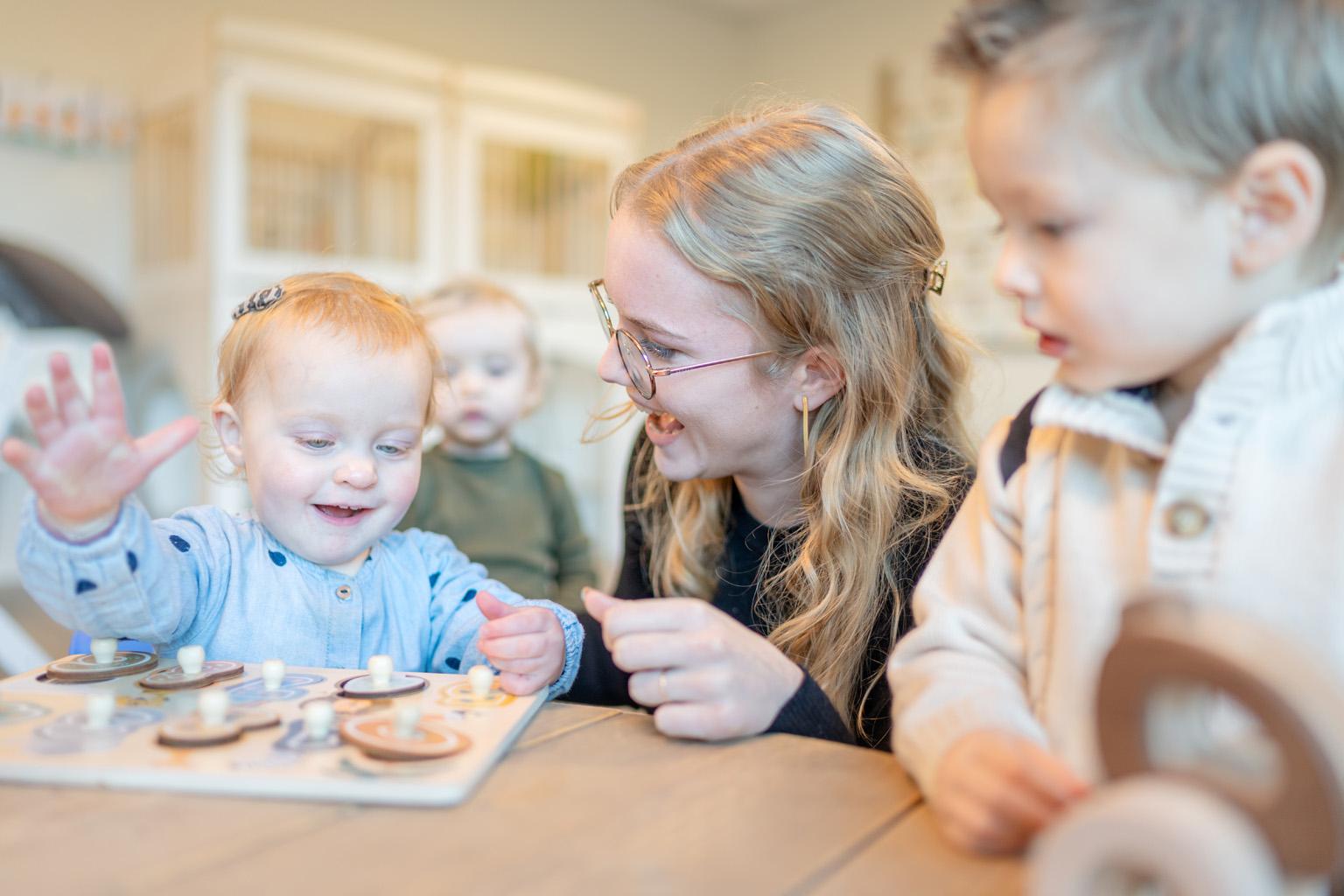 Pedagogisch medewerker en kind maken samen plezier