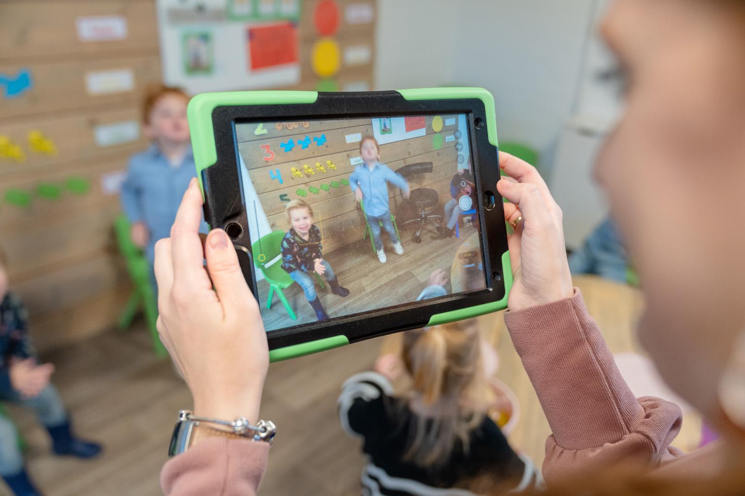 pedaogogisch medewerker maakt foto voor ouderapp