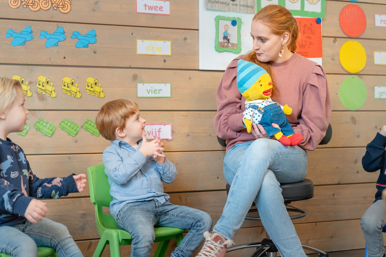 Pedagogisch medewerker met vriendje Puk op de groep
