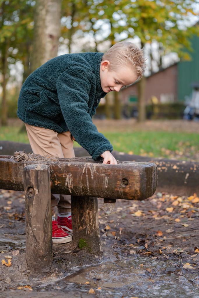 Jongen speelt in de modder BijdeHandjes