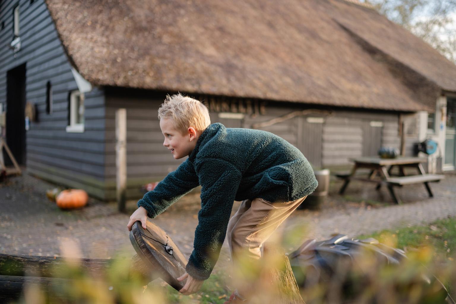 Jongen klimt op boomstam